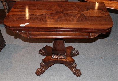 Lot 1300 - A William IV style rosewood fold-over tea-table raised on carved paw feet