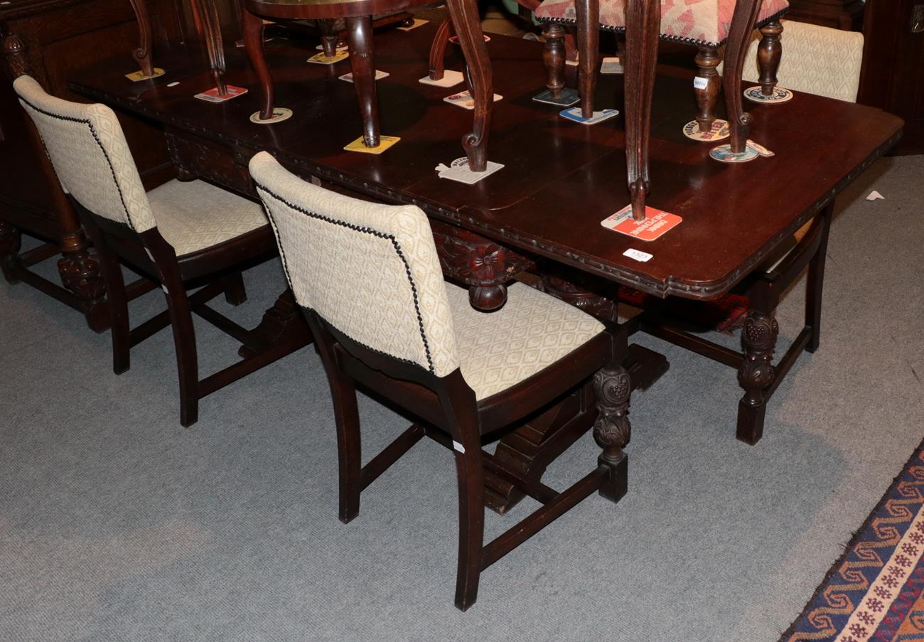 Lot 1323 - A carved oak dining room suite comprising of a dining table; a sideboard and four chairs; and...