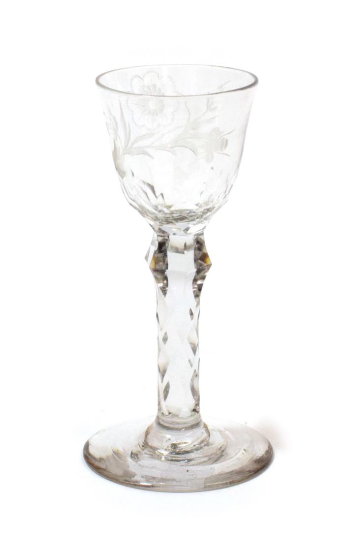 Lot 1006 - A Wine Glass, circa 1780, the rounded funnel bowl engraved with a flower on a knopped faceted stem