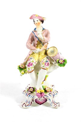 Lot 1021 - A Bow Porcelain Figure of a Drummer, circa 1765, modelled seated, his drum at his side, on a...