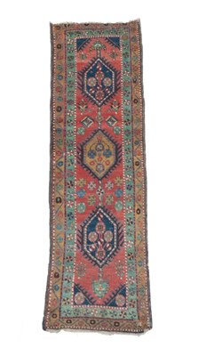 Lot 1192 - Narrow Heriz Runner  North West Iran, circa 1910 The brick red field with a column of octagons...