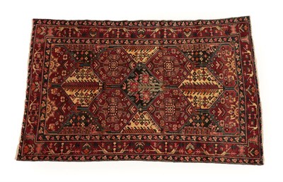 Lot 1216 - Bakhtiyari Rug West Iran, circa 1940 The polychrome honeycomb lattice field of stylised flower...