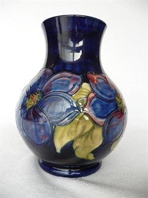 Lot 1411 - A Walter Moorcroft "Clematis" Baluster 869 Vase, on a blue ground, impressed factory marks, painted