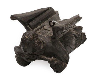 Lot 1319 - A Carved Oak Figure of an Angel, 19th century, modelled in flight whilst playing a musical...