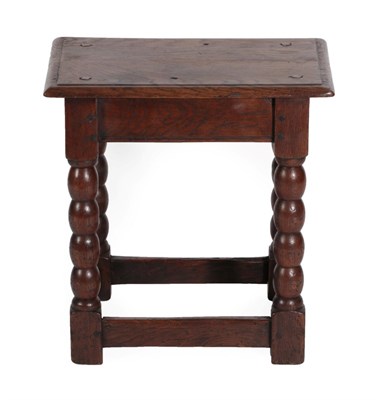 Lot 1358 - An Oak Joint Stool, the four peg moulded top on bobbin turned legs joined by a peripheral stretcher