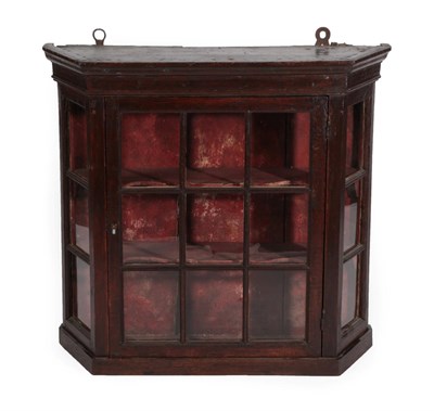 Lot 1360 - An 18th Century Oak and Stained Pine Hanging Display Cabinet, the hinged glazed door between canted