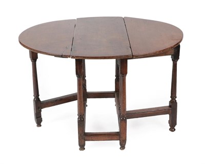 Lot 1404 - ^ An Early 18th Century Oak Gateleg Table, with two drop leaves to form an oval, on gun barrel...