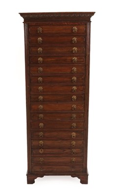 Lot 1457 - An Early 20th Century Oak Sixteen Drawer Straight Front Chest, the moulded top above an egg and...