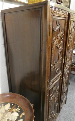 Lot 14 - A Chinese Hardwood Cupboard, 20th century, the two twin-panelled doors carved with dragons...