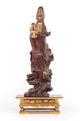 Lot 35 - A Parcel Gilt Rootwood Figure of Guanyin, Qing Dynasty, standing wearing flowing robes holding...