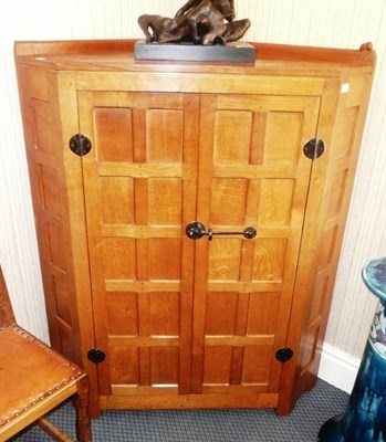 Lot 1498 - A Robert "Mouseman" Thompson Panelled Oak Corner Cupboard, with raised upstand above two doors with