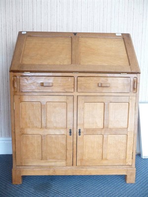 Lot 1513 - An Alan Grainger Acorn Industries Oak Bureau, with fall front, above two drawers above two cupboard