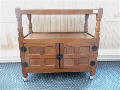 Lot 1524 - A Sid Pollard Oak Tea Trolley, the two tiers above two panelled cupboard doors, wrought iron hinges