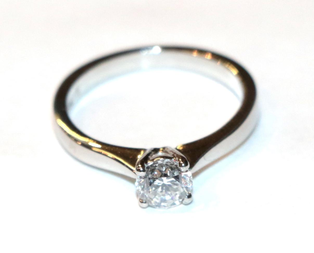 Lot 216 - A platinum diamond solitaire ring, a round brilliant cut diamond in a claw setting, to knife...