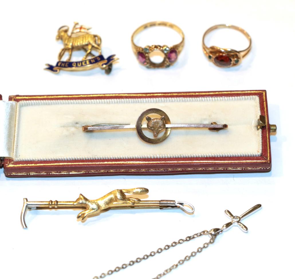 Lot 237 - A fox mask stock pin, stamped '9CT', length 4.7cm; a running fox and hunting crop bar brooch,...