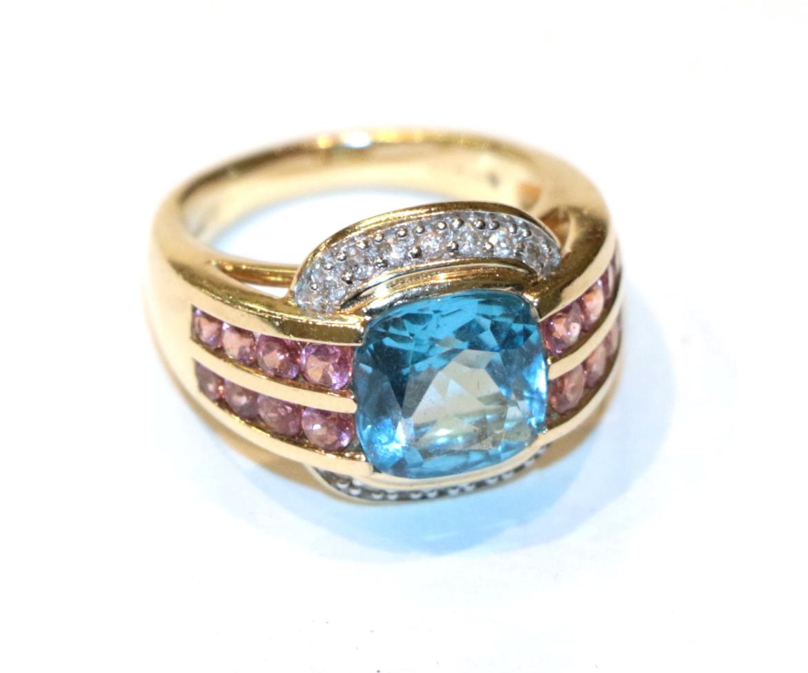 Lot 255 - A 14 carat gold blue topaz within a border of pink stones ring, finger size L1/2
