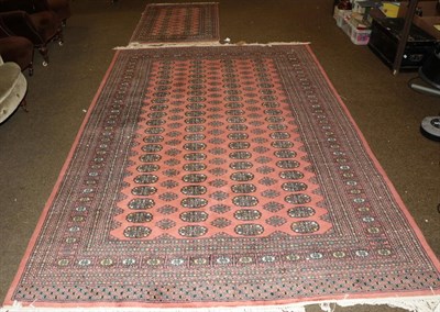 Lot 423 - Bokhara Carpet, the soft coral pink field with four columns of guls enclosed by multiple...