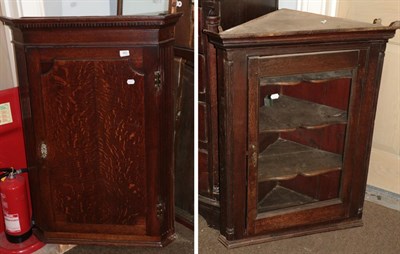 Lot 483 - A George III oak hanging corner cupboard, with fluted stiles; and a glazed oak example (2)