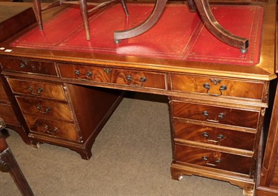 Lot 509 - A reproduction mahogany pedestal desk with tooled red leather writing surface