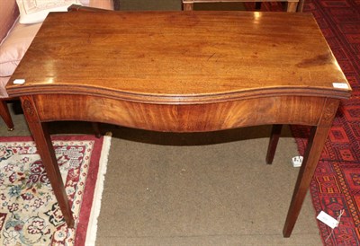 Lot 543 - A George III mahogany serpentine shaped tea table, fold-over top, inlaid shell paterae, square...