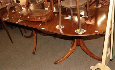 Lot 551 - An early 20th century mahogany twin pedestal dining table with one additional leaf, 208cm fully...