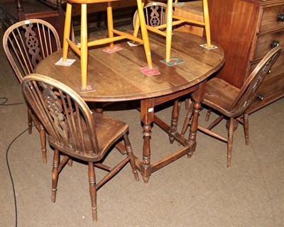 Lot 561 - An oak gateleg table, baluster turned legs; together with a set of four wheel back chairs (5)