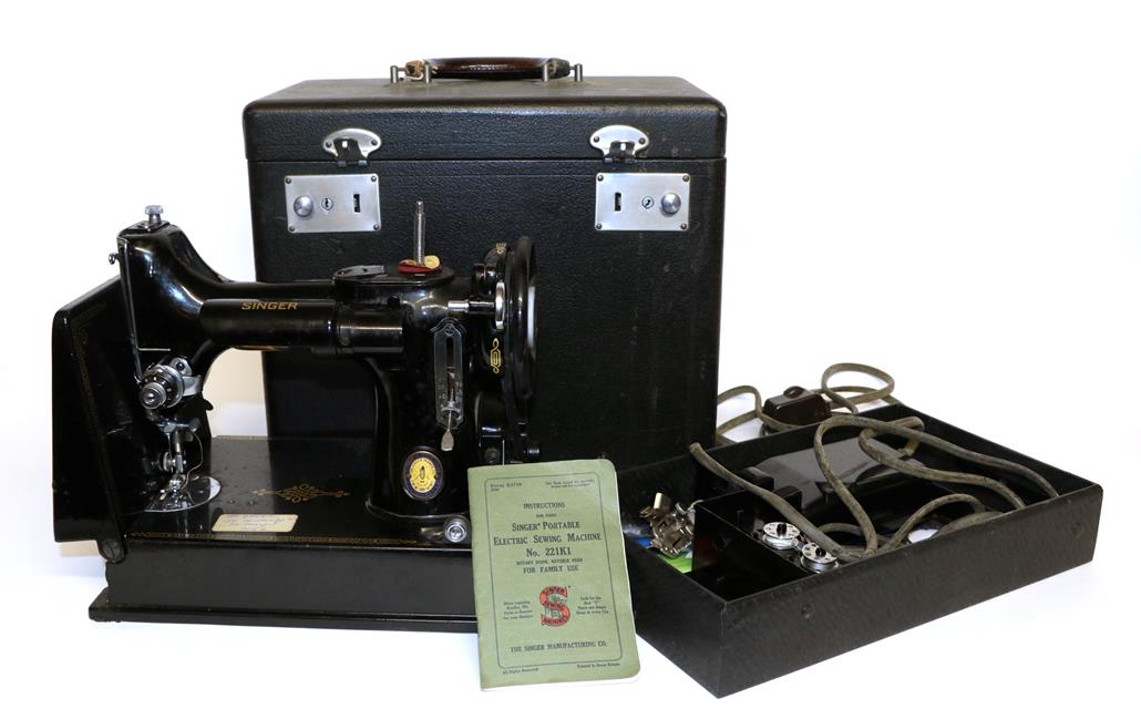 Lot 2022 - A Singer Portable Sewing Machine No 221K1, together with accessories including the rubber mat,...