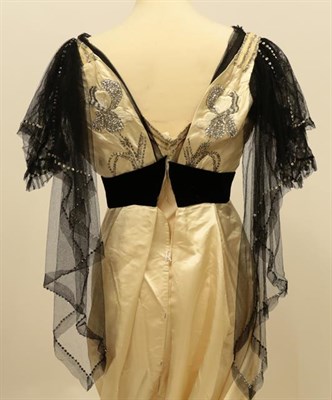 Lot 2048 - A Edwardian Cream Silk Evening Dress, with black net capped sleeves, with stylish paste...