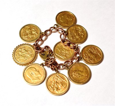 Lot 24 - A charm bracelet stamped '9' and '.375' hung with nine full sovereigns dated 1915, 1908, 1974,...