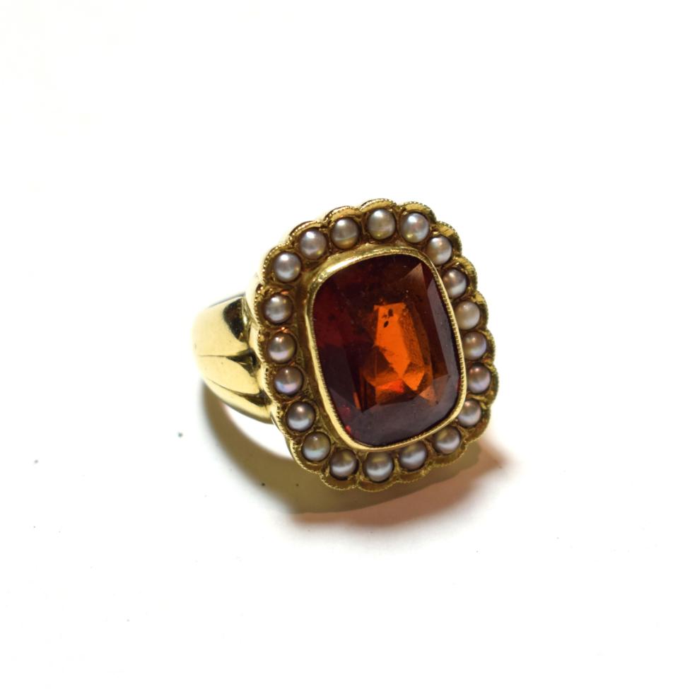 Lot 32 - An 18 carat gold hessonite garnet and seed pearl cluster ring, the cushion cut hessonite garnet...