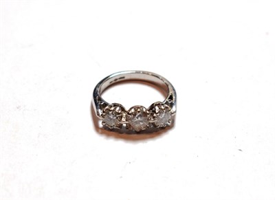 Lot 172 - A platinum diamond three stone ring, the graduated round brilliant cut diamonds in claw...