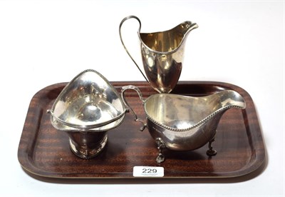 Lot 229 - A George III silver cream-jug; a George III silver sweetmeat-basket; and a George VI silver...