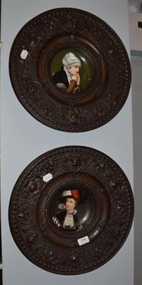 Lot 276 - A pair of circular brass plaques with central porcelain plaques depicting portraits