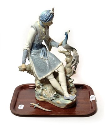 Lot 287 - A Lladro model of an Indian figure and a peacock