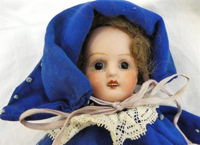 Lot 1050 - A late 19th century wax shoulder head doll with blue eyes and wig, on fabric body with papier mache
