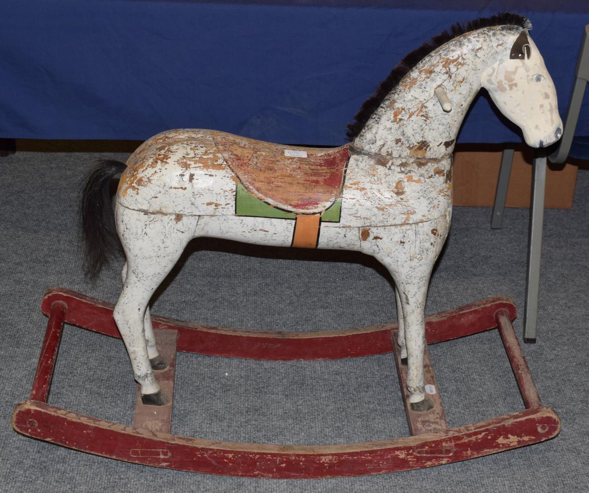 Lot 1070 - A naively painted and carved small wooden rocking horse on rocking treadle base