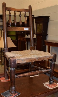 Lot 1184 - A 19th century spindle back child's chair, with a rush seat, 62cm high