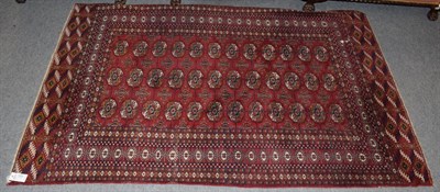 Lot 1220 - A Bukhara rug, the brick red field with columns of guls enclosed by multiple borders, 200cm by...