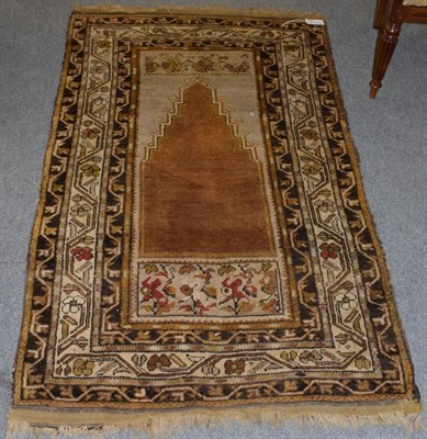 Lot 1221 - Anatolian prayer rug, the stepped field beneath the Mihrab enclosed by meandering vine borders,...