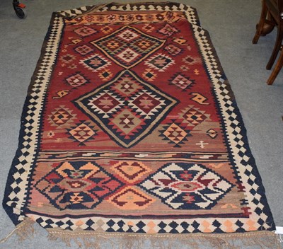 Lot 1229 - Shahsavan kilim, the abrashed brick red field of diamond medallions enclosed by geometric motif...