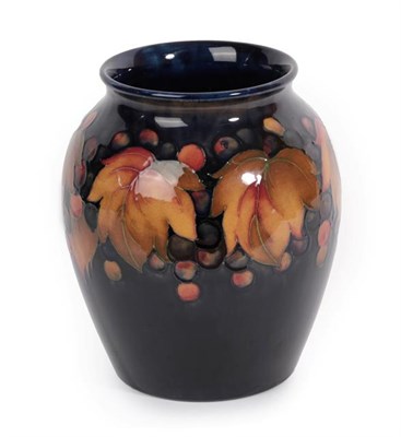 Lot 1042 - William Moorcroft (1872-1945): A Leaf and Grape Pattern Vase, on a blue ground, blue painted...