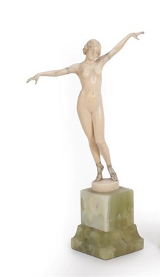Lot 1103 - An Art Deco Ivory Figure, circa 1920, of a nude maiden, stood on tiptoes with both arms...