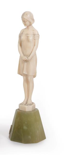 Lot 1104 - An Art Deco Ivory Figure, circa 1920, of a girl modelled standing, with her arms in front,...