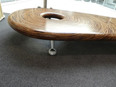 Lot 1214 - A Clayton Tugonon Coffee Table, curved form with circular hole, on silver coloured legs,...