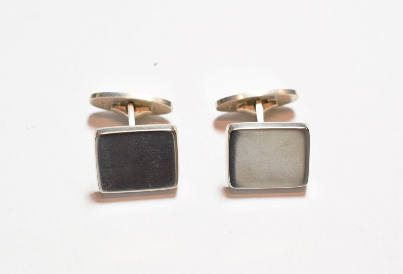 Lot 185 - A pair of silver cufflinks, by Georg Jensen, the rectangular plaque with a swivel bar, numbered...