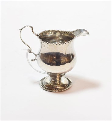 Lot 245 - A George III silver cream-jug, maker's mark NS and AN, London, 1766, baluster and with beaded...