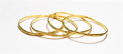 Lot 310 - Four fancy yellow bangles