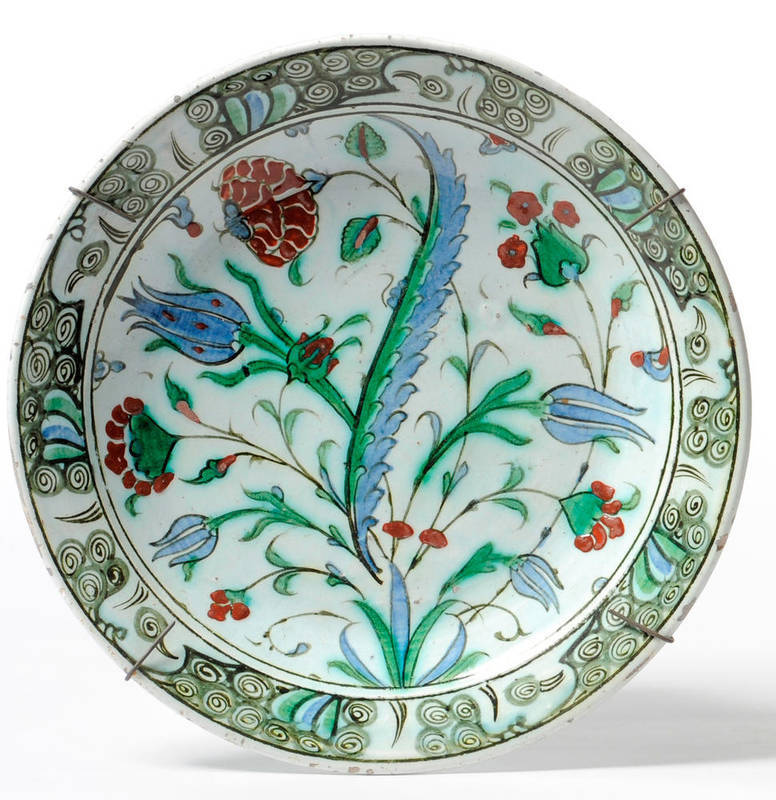 Lot 231 - An Isnik Dish, 17th century, of shallow circular shape, the central field painted with tulips...