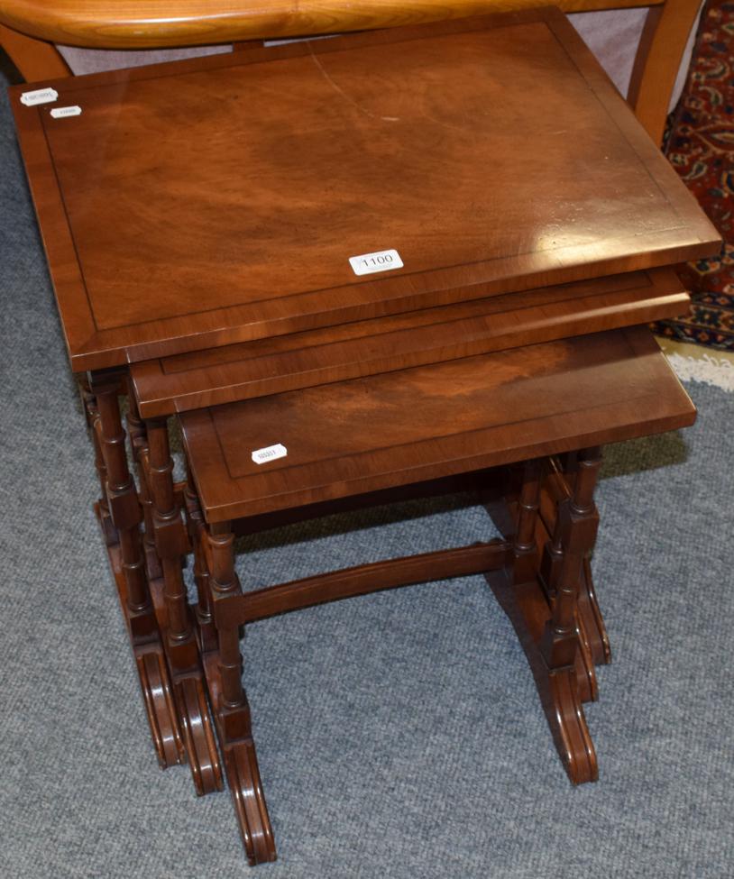 Lot 1100 - A reproduction walnut drop leaf coffee table, a nest of three tables, and a mahogany three tier...