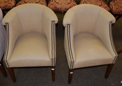 Lot 1105 - A pair of tub chairs upholstered in mustard coloured fabric